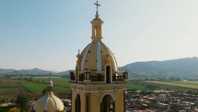Slow-motion aerial orbit view of the Santuario Diosesano church's bell tower in Tamazula de Gordiano