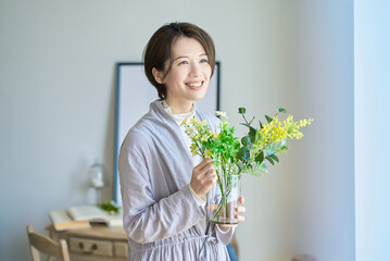 花を飾った花瓶を持つ女性