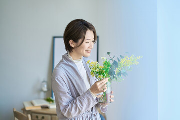 花を飾った花瓶を持つ女性