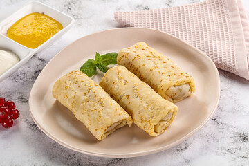 Homemade stuffed pancakes with honey and cream sour