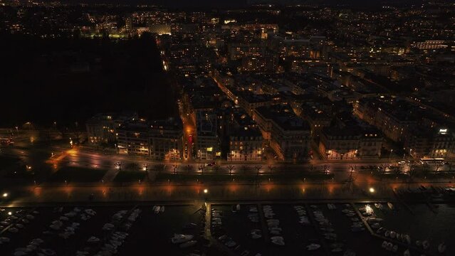 Tracking shots of Geneva's waterfront at night, capturing traffic in the street and boats docking in marina