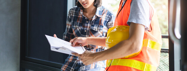 Client and contractor look at blueprint and planning to renovation room.