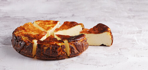 Homemade Basque burnt cheesecake slice on light background, , copy space