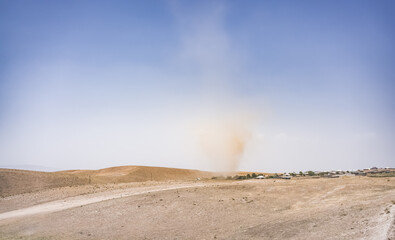 A dust whirlwind turns into a tornado in a desert area in Tajikistan, a wind tornado