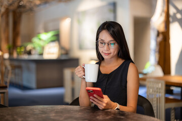 Woman look at the mobile phone in coffee shop