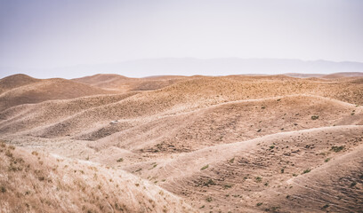 Panoramic landscape of hills with dry yellow grass in Tajikistan, sun-dried hills