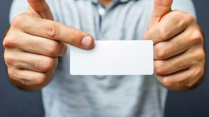  A man, right hand holding a white business card aloft, left hand extending a thumbs-up