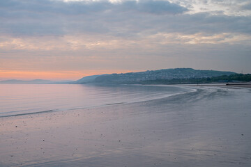 Sunrise long exposure of sea groynes at the costal holiday seaside resort of Rhos-on-Sea, Wales, UK.