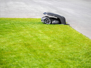 Robotic lawn mower on grass and pavement