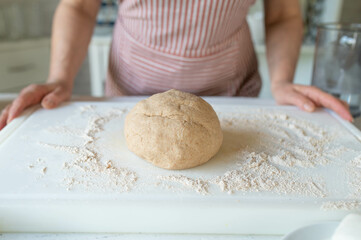 Woman with a fresh kneaded whole wheat pizza dough