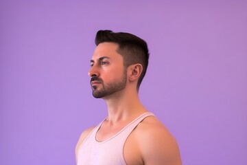 A man with a beard and mustache is standing in front of a purple background