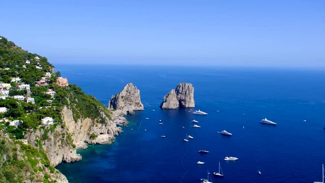 Luxury yacht by Faraglioni di Capri. Boats take tourists to the famous Faraglioni di Capri, in Italy.