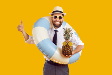 Portrait of happy funny man in sunglasses and beach hat wearing office clothes with rubber ring and...