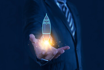 Businessman showing startup business icons on modern virtual interface rocket, idea, growth,...