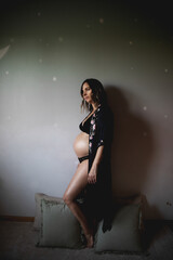A pregnant woman waits happily in her child's room.
