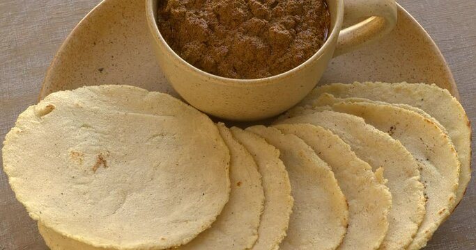 Homemade corn tortillas made with nixtamalized corn flour. Veracruz-style thick sauce made with dried chilies, pumpkin seeds, and unhulled sesame seeds. Traditional Mexican meal. Table spin.