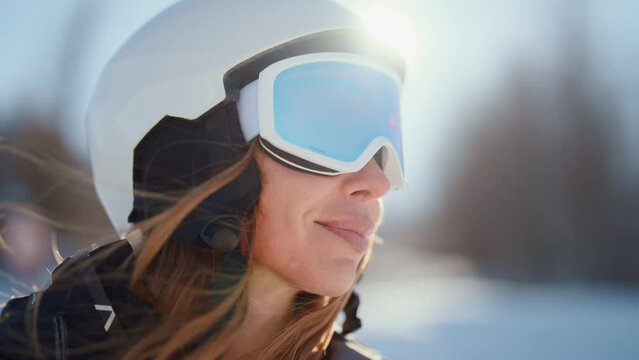 Close-up portrait of woman snowboarder skyer in ski helmet and glasses in mountains, side view. Girl wearing in ski clothes in winter resort. Enjoy healthy sport active travel, sports lover lifestyle.