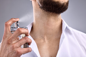 Hand, bottle and cologne with a man in studio on a white background for perfume, fragrance or...