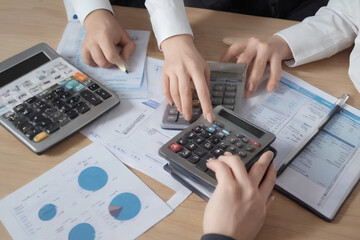 Accountant team analyzes financial data and accounting records using a calculator.