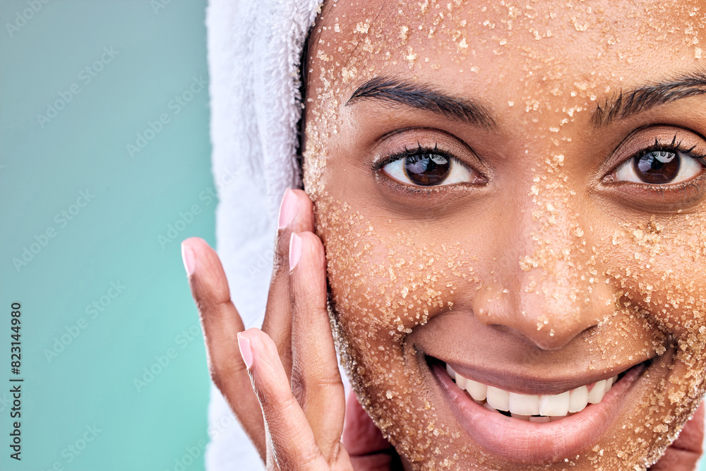 Wall mural Woman face, beauty and salt scrub with skin care, exfoliation and wellness or dermatology in studio. Portrait of model with sugar texture for cosmetics and makeup removal or facial on blue background