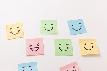 Colorful sticker notes with smiley face on white wall