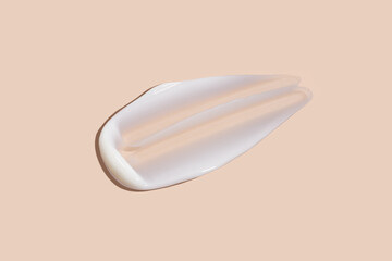 Cosmetic smear of creamy texture on a pastel beige background