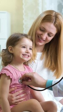 Male pediatrician examines baby with a stethoscope.