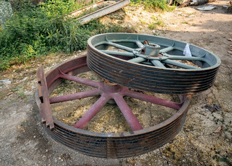 A large wheel part of the machine lay on the ground