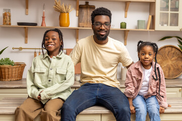 Cheerful dad with happy little children daughters having fun at home