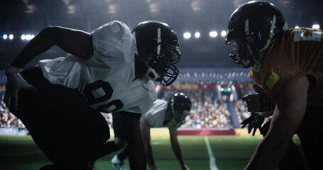 Cinematic Footage of an American Football Match with Players Standoff Before Action, Tackles, and Strategic Plays Begin. Professional Male Footballers Fighting for the Ball, Playing a Dominant Game - Powered by Adobe