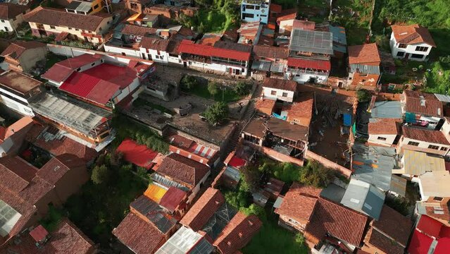 Enjoy a stunning descending aerial shot towards San Blas Lookout, showcasing the Tejas roofs and green courtyards in Cusco