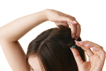 Naklejka premium Close up of young brunette woman's head with silky, straight hair holding capsule with oil against white background. Concept of hair treatment, hygiene, spa procedures, wellness. Ad
