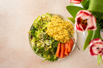 Delicious healthy breakfasts, bulgur porridge with red salmon fish and a salad mix with fresh vegetables, avocado and various seeds, a healthy balanced breakfast with fats, fiber and protein