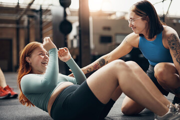 Laughing woman getting encouragement from a partner during a sit-ups workout