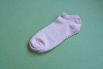 Pink cotton socks on a green background.