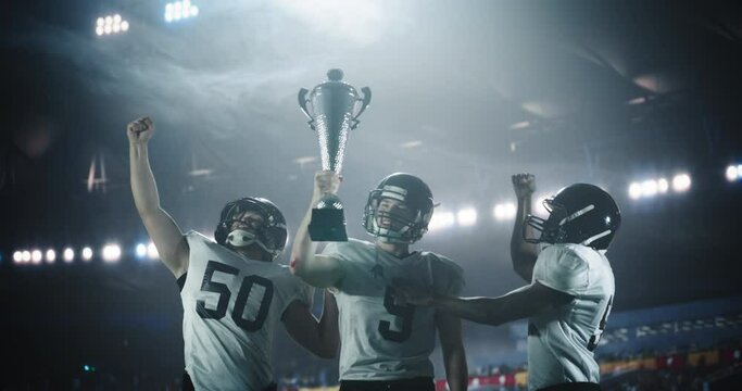 American Football Team Celebrating Victory. Three Footballers Holding a Gold Trophy in the Air. Players Raising Arms in Joy. Championship Game Win as Proof of Dedication, Team Spirit and Success