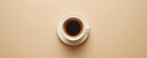Aerial view of a cup of black coffee in a white cup on a beige background, creating a minimalistic...