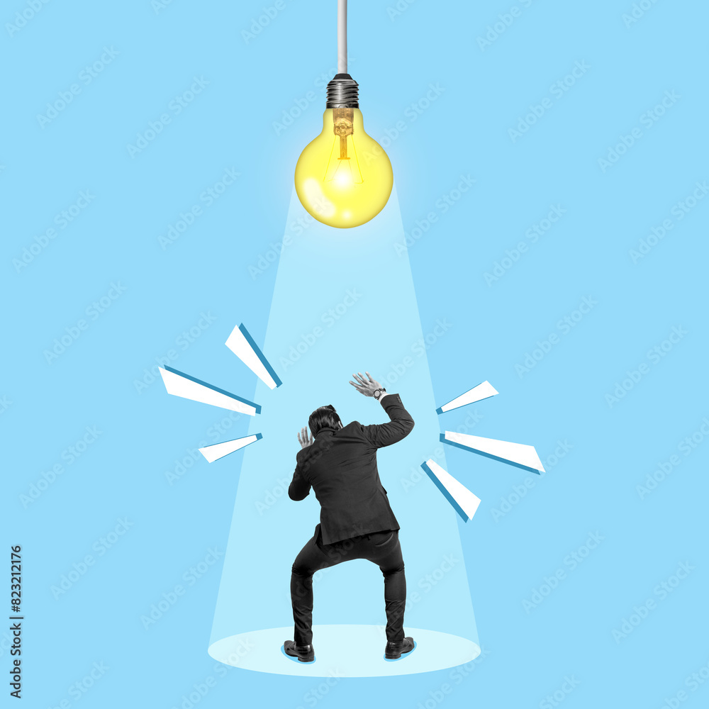 Wall mural a businessman standing below a bright light bulb as a symbol of new ideas