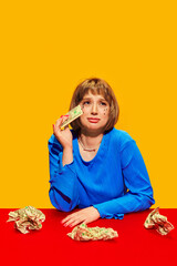 Financial Heartbreak. Stylish young woman crying into money against bright yellow background....