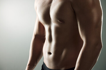 Fototapeta premium Muscle, strong and body of man for workout, health and exercise for training goal on white studio background. Portrait, sports and bodybuilder model with sexy, young and healthy abs from fitness