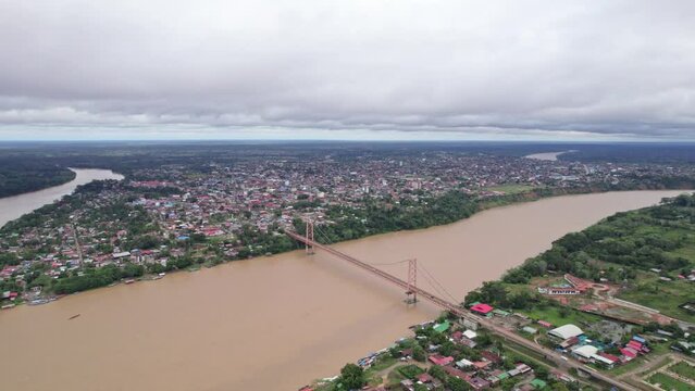 Enjoy the panoramic view of Puerto Maldonado with its iconic hanging bridge over the majestic Tambopata River. From left to right, follow the course of the river in this stunning aerial shot