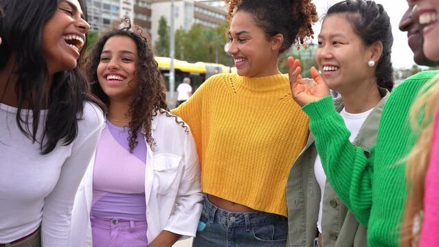 Multi ethnic group of young women hugging outside - Happy girlsfriends having fun laughing out loud on city street - Female community concept with cheerful girls standing together	
