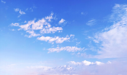 Clear blue sky texture and white fluffy cloud nature background. The sun shines bright in the...