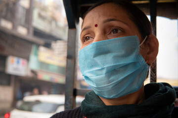 Close up portrait of Indian mature woman sitting in public transport electric auto rickshaw with...