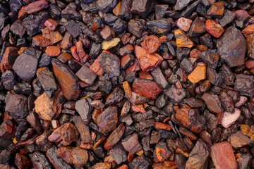 Wet screened manganese (dark) and waste, barren in manganese (brighter colored), rocks