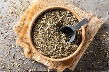 Traditional yerba mate in bowl on wooden table. Top view