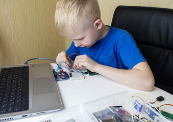 Programming for children. The boy is studying online at a robotics school for programming courses....