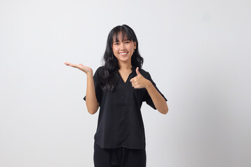 Portrait of attractive Asian woman in casual shirt promoting product, pointing finger to the side. Advertising concept. Isolated image on white background