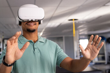 A biracial male physical therapist wearing virtual reality headset at gym rehabilitation center, exp