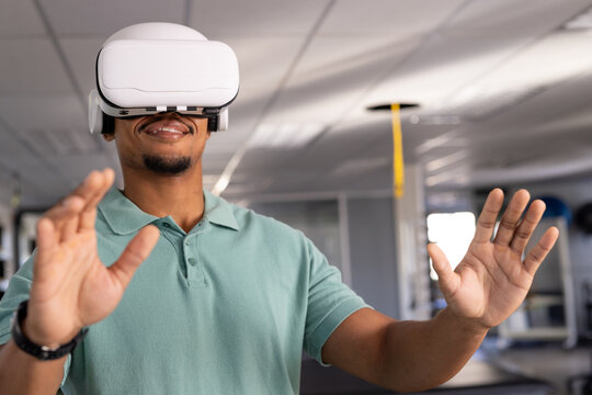 A biracial male physical therapist wearing virtual reality headset at gym rehabilitation center, exp